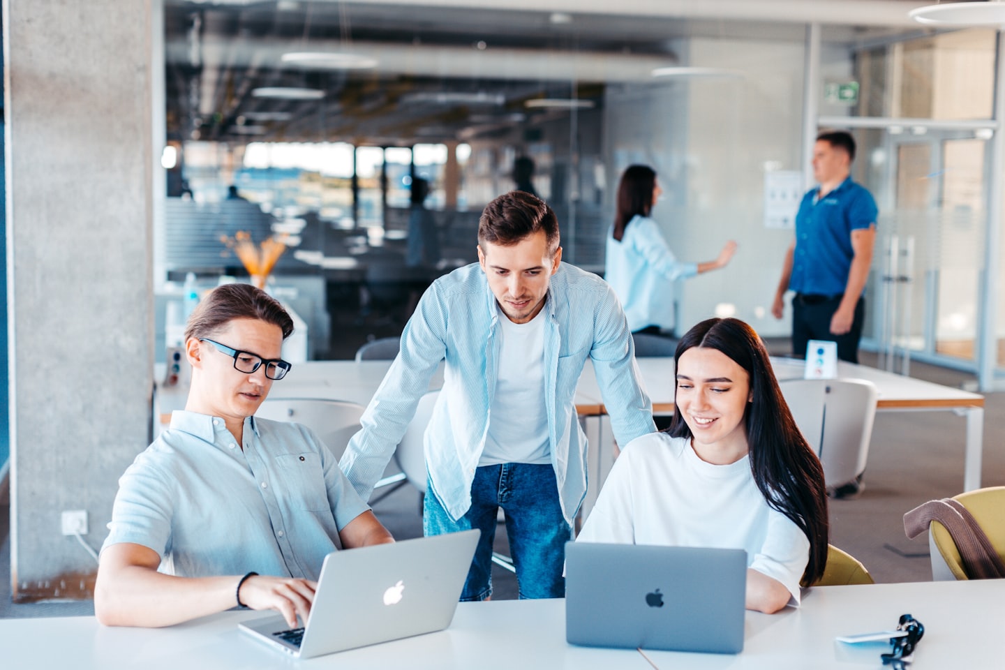 Collega's die samenwerken op laptops aan een kantoortafel.